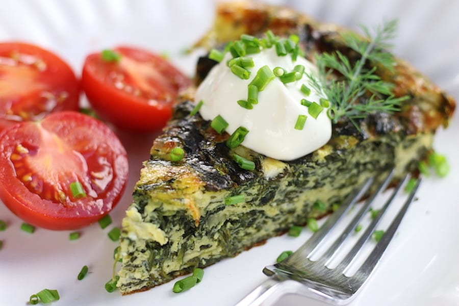 Spinach and Feta Quiche slice with fresh cut tomatoes.