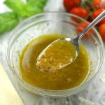 A spoonful of Red Wine Vinaigrette being scooped from a bowl.