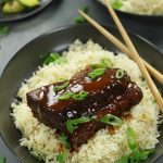 Asian Braised Beef Ribs coated in a savory, rich glaze and garnished with freshly chopped green onions.